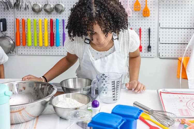 A student practices kitchen measurement during a lesson