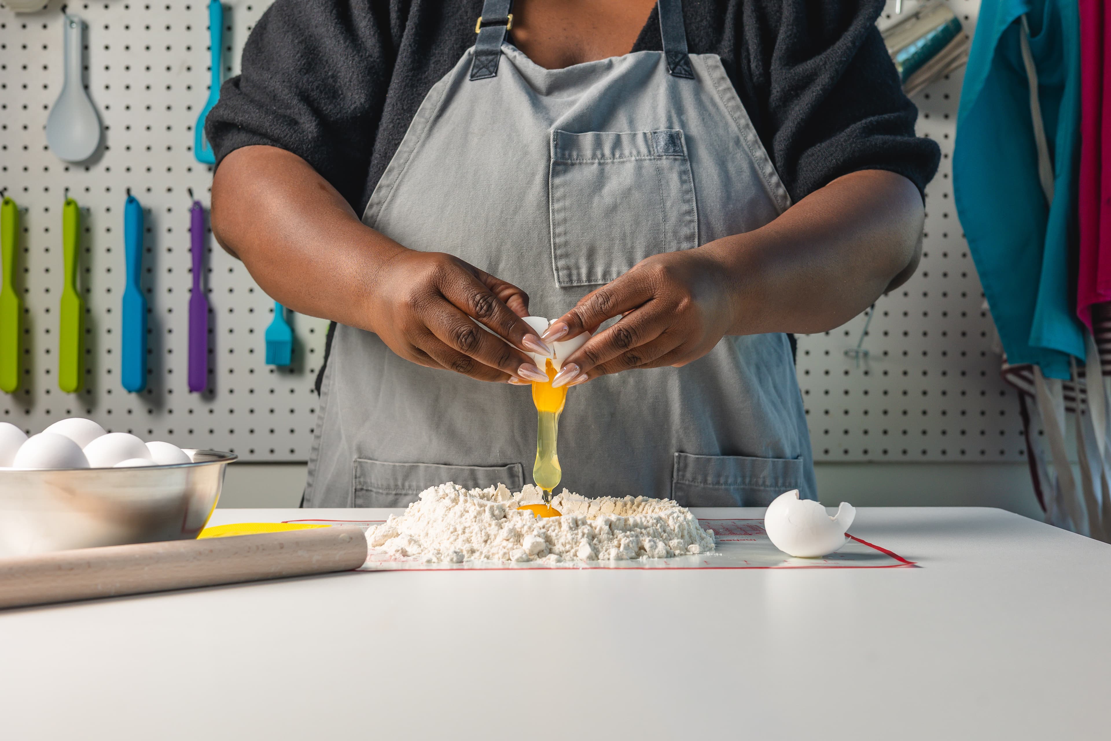 An adult cook works at a classroom prep station