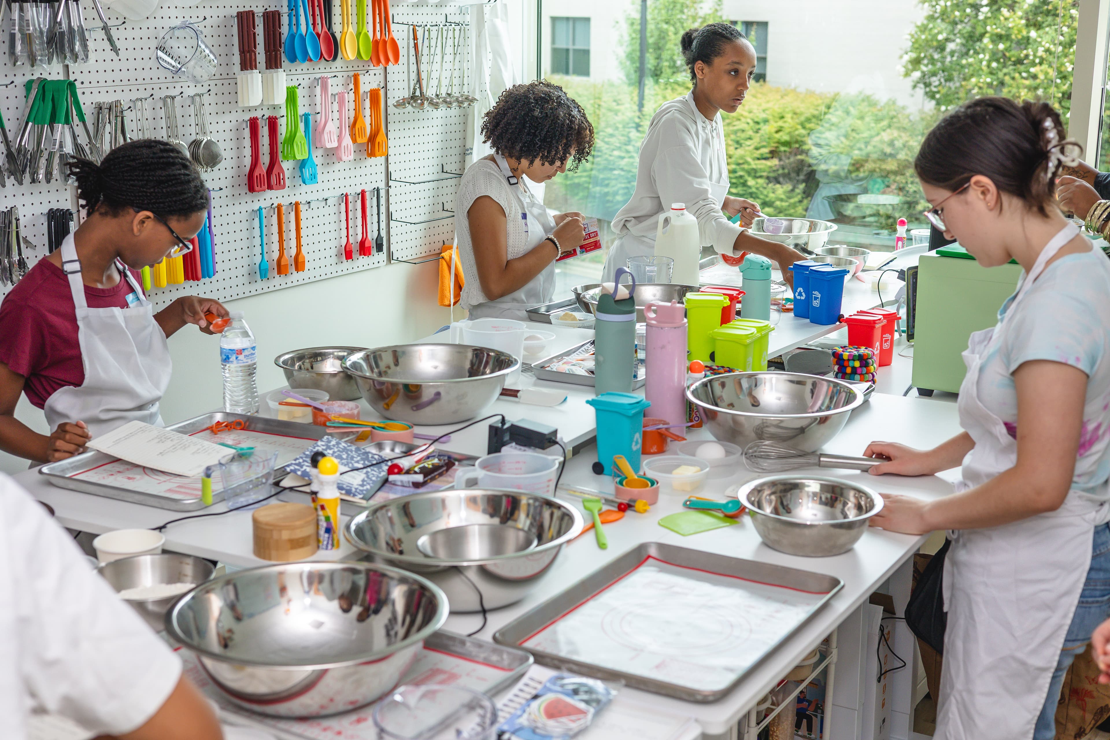 A young cook studies measurements beside bowls and kitchen tools