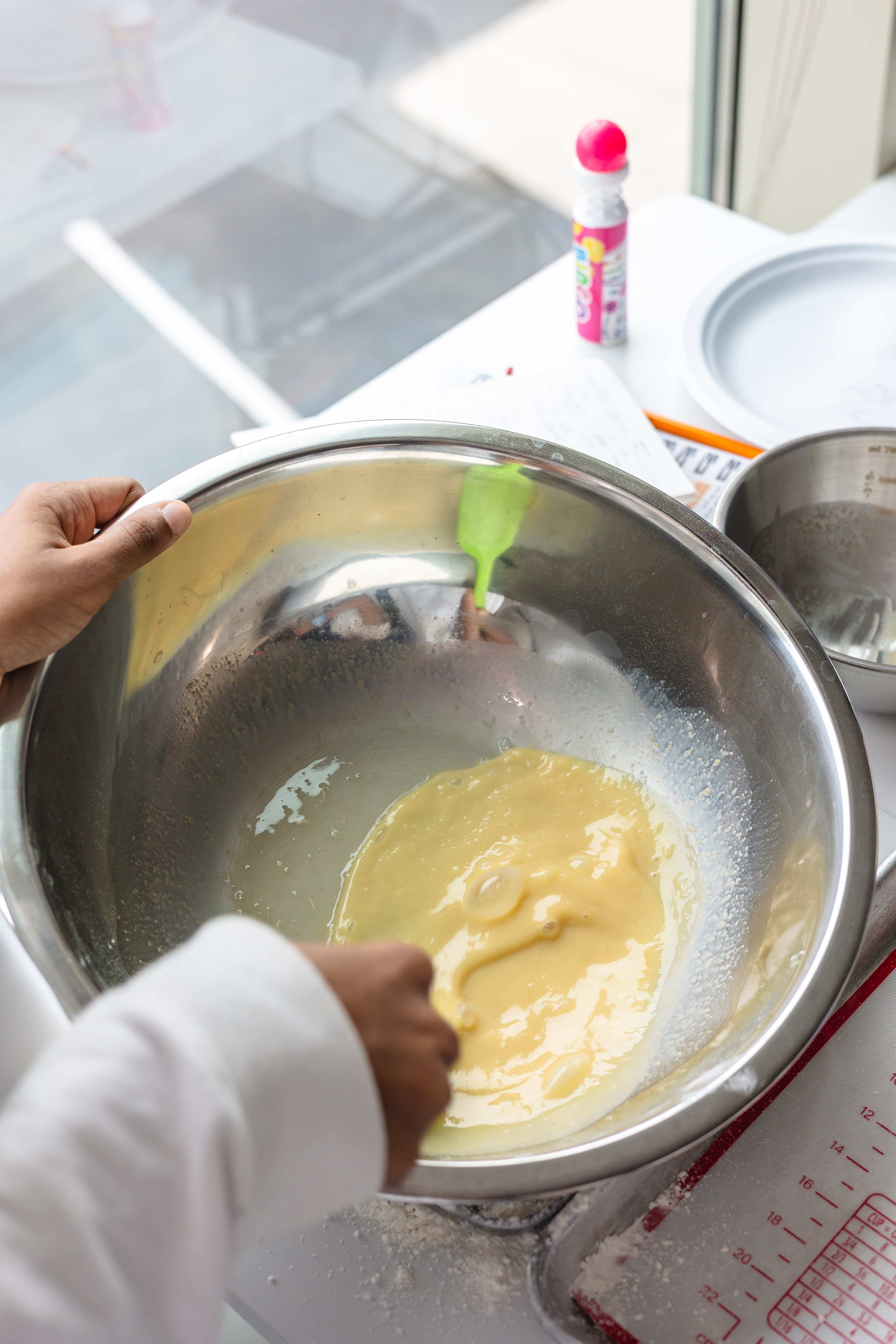 A young cook studies measurements beside bowls and kitchen tools